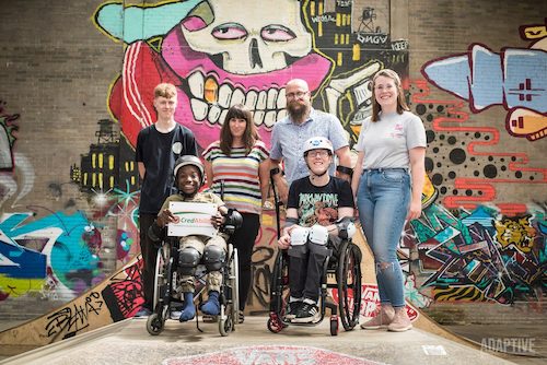 Nimbus Disability group photo. Includes two children in wheelchairs smiling.