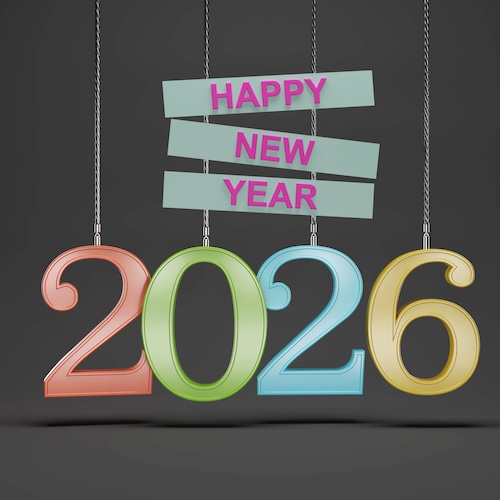 The numbers 2026 in red, green, blue and gold letters hanging from the ceiling on wires in front of a plain grey background with the words Happy New Year in pink on white blocks above them.