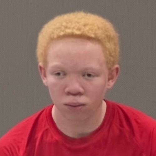 Kiitan Bayo-Awonaike wearing a red Bolton Futsal shirt, looking focused and determined during a match or training session.