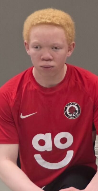 Kiitan Bayo-Awonaike wearing a red Bolton Futsal shirt, looking focused ahead of a match or training session.